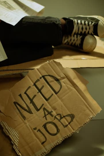 IMAGEN DE ALGUIEN QUE BUSCA EMPLEO ESCRITO EN UN CARTÓN. NEED A JOB. 