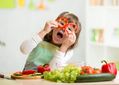 Niña jugando con hortalizas