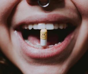 Persona con una pastilla en la boca que indica la automedicación